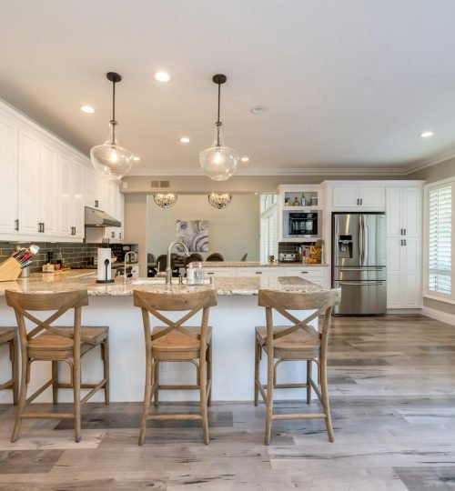 Bright and spacious kitchen interior featuring bar stools and modern design elements.